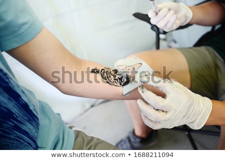 Foto stock: Applying Temporary Tattoo