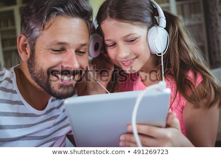 Zdjęcia stock: Father And Daughter Listening To Music On Tablet