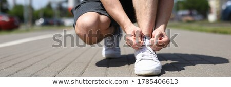 Сток-фото: Sportsman Tying Shoelaces On Sidewalk