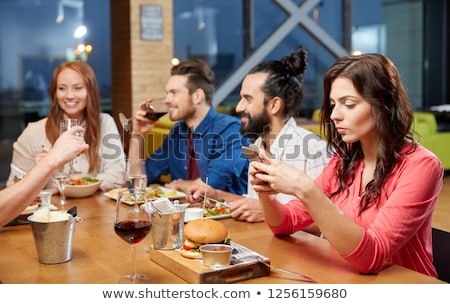 Stock photo: Bored Woman Messaging On Smartphone At Restaurant