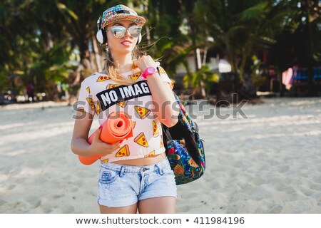 Zdjęcia stock: A Beautiful Woman Walks In Summer Short Denim Shorts With A White Backpack On Her Back