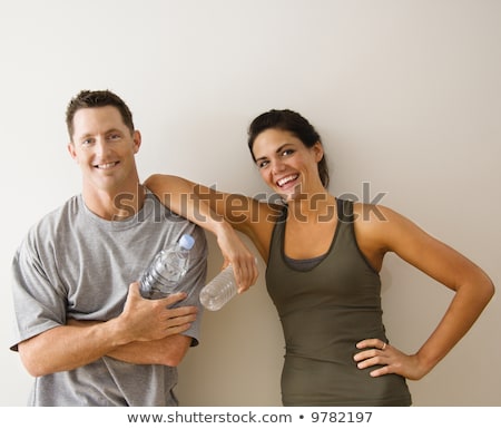 Portrait Of Woman In Fitness Attire Holding Water Bottle And Smi Imagine de stoc © iofoto