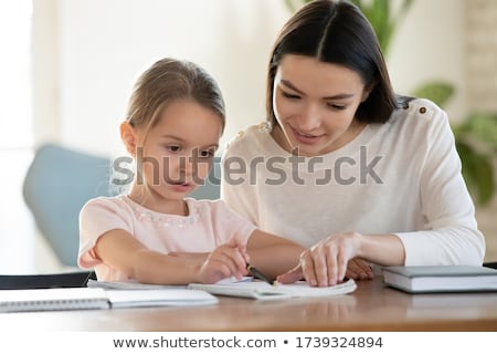 Stok fotoğraf: Teacher Helps To Little Girls To Make An Exercises In Classroom