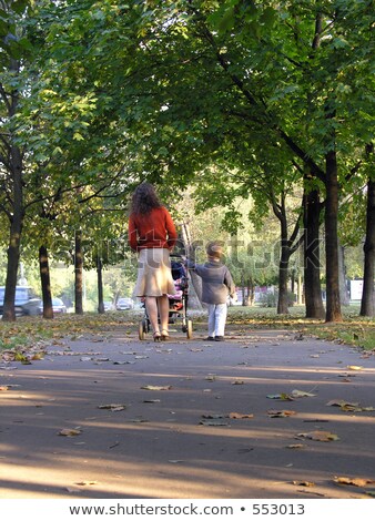 Foto stock: Adre · con · hijo · y · bebé · a · pie · en · otoño · chico