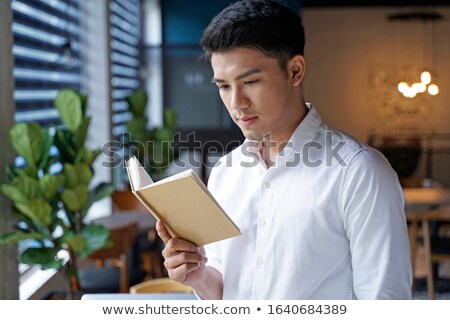 Foto stock: Surprised Businessman Holding An Open Notebook