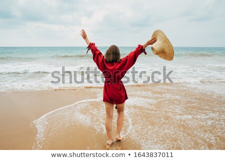 Foto stock: Girl In Red Swimsuit Posing With Hands Up Outdoors