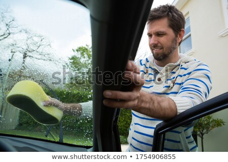 Foto d'archivio: Auto Service Staff Washing A Windscreen With Sponge