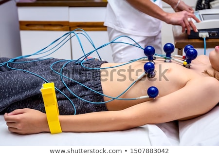 [[stock_photo]]: Doctor Attaching Sensors On The Patient For Electrocardiogram Test