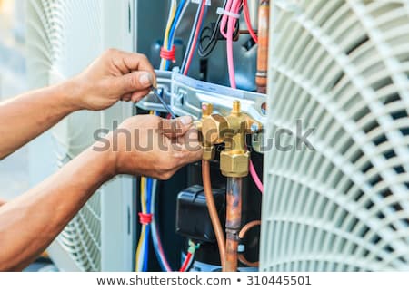 Foto d'archivio: Worker Repairing Air Condition Equipment