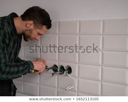 Stock photo: Electrician Unscrewing Face Plate Of Plug Socket