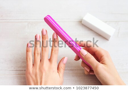 [[stock_photo]]: Young Woman Filing Her Fingernails