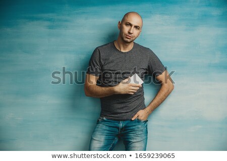 Stockfoto: Bald Man Presenting With One Hand In Pocket