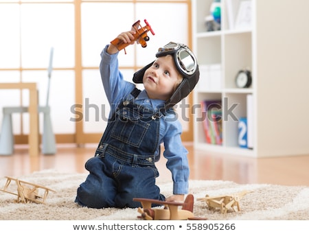 Foto d'archivio: Happy Little Boy Playing With Airplane Toy At Home