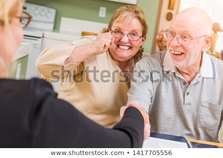 Zdjęcia stock: Senior Adult Couple Celebrating Over Documents In Their Home Wit