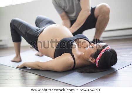 Stock photo: Trainer With Pregnant Woman Doing Yoga In A Fitness Studio