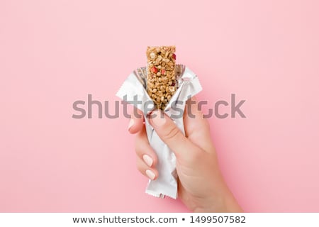 Stock photo: Young Woman Eating A Cereal Bar