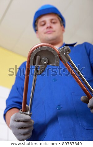 Foto stock: Man Using Copper Pipe Bending Tool