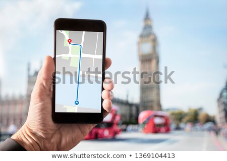 Foto stock: Hand Holding Smartphone With City Guide In London