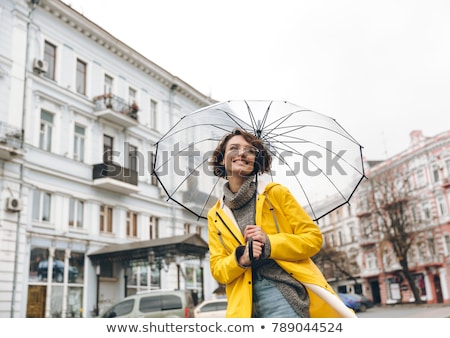 Stok fotoğraf: Optimistic Woman In Yellow Raincoat And Glasses Having Fun While