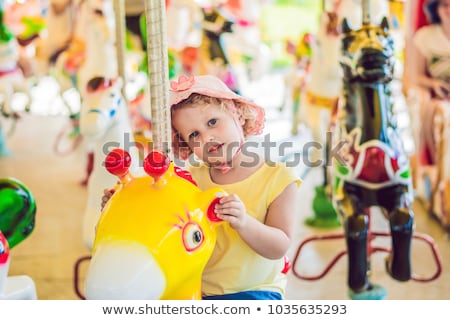 Stock photo: Cute Little Boy Enjoying In Funfair And Riding On Colorful Carousel House