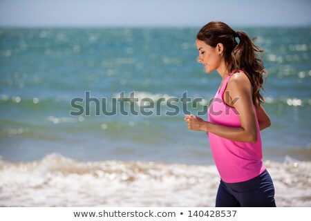 Imagine de stoc: Young Woman Jogging On The Beach In Summer Day Athlete Runner Exercising Actively In Sunny Day