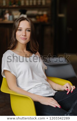 Foto stock: Beautiful Woman With Dark Hair Heathy Skin Pleasant Appearance Dressed In Casual Outfit Feels Rel