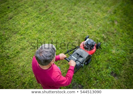 Foto stock: Senior Man Mowing His Garden - Shot From Above - Interesting Ang