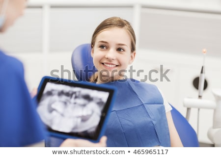 Foto stock: Happy Kid Patient With Tablet Pc At Dental Clinic