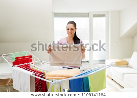 Foto d'archivio: Woman Taking Bath Towels From Drying Rack At Home