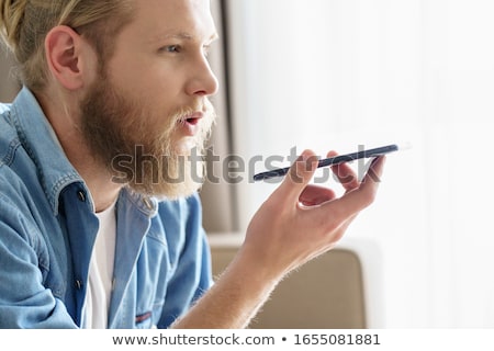 Foto stock: Bearded Man Using Voice Assistant On Mobile Phone