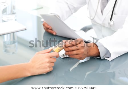 Foto stock: Close Up Of A Doctor Giving Drugs To His Patient During An Appointment In His Office