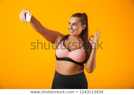 Сток-фото: Portrait Of Happy Chubby Woman In Sportive Bra Using Mobile Phon