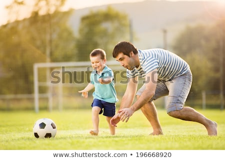 Stockfoto: Young Father With His Little Son Playing Football On Football Pitch