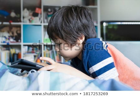 ストックフォト: Boy Playing On Electronic Gadget Tablet In His Bedroom Social Problem Of Communication Of Children