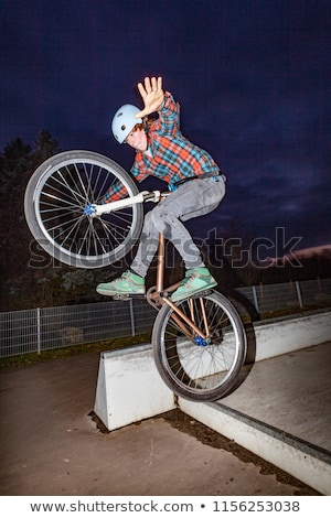 Stock fotó: Boy Jumps Over A Ramp With His Scooter On The Skate Park