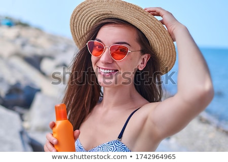 Zdjęcia stock: Happy Young Woman In Swimsuit Holding Sunscreen