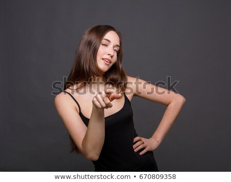Stock fotó: Portrait Of A Woman Pointing Finger At Camera And Winking
