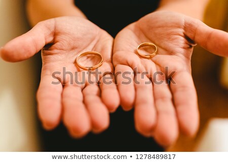 Stok fotoğraf: Newlywed Rings Shown In The Hands Of The Bride And Groom