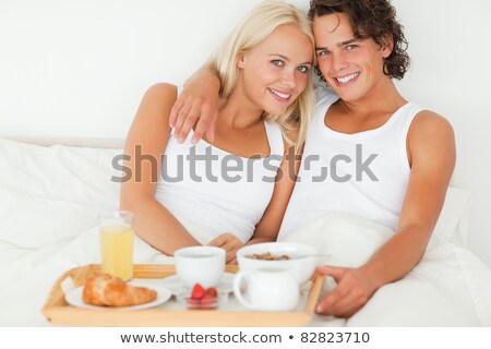 Stockfoto: Happy Couple Eating Fruits Lying On Their Bed