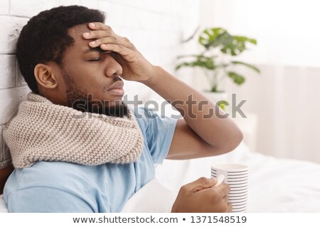 Stockfoto: Man With Fever Holding Cup Of Tea