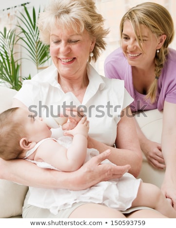 Сток-фото: Close Up Of A Proud Mother Bottle Feeding Her Baby Sitting In The Sofa In The Baby Bedroom