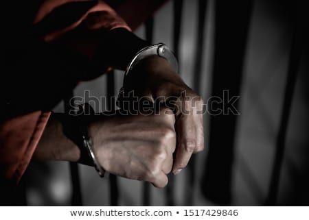 Foto stock: Woman Hands Behind The Bars