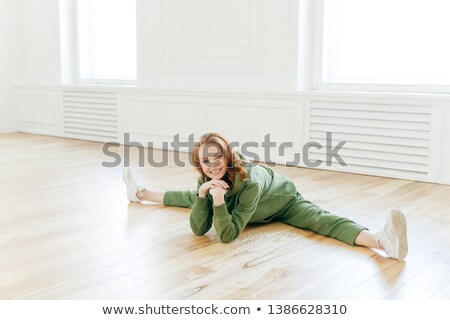 Сток-фото: Glad Refreshed Sporty Red Haired Woman Has Work Out In Empty Hall Demonstrates Flexibility Exercise