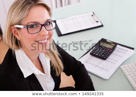 Foto stock: Young Businesswoman Is Calculating And Writing On A Paper