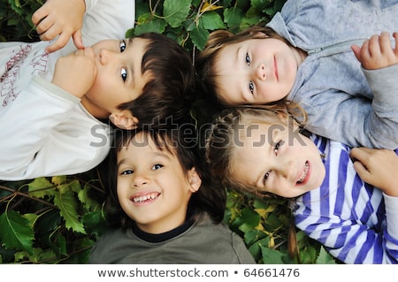 Foto stock: Children Group In Circle Laying On Ground