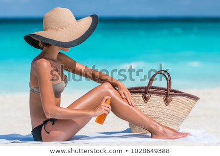 Stockfoto: Woman Spraying Sunscreen Suntan Lotion At Beach