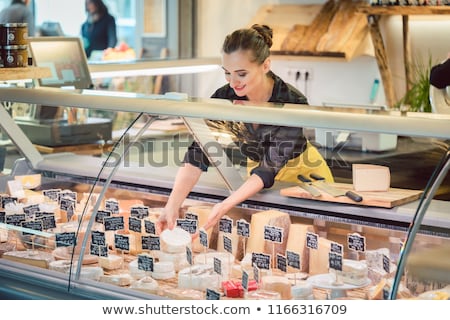 Beautiful Woman Offering Cheese On Delicatessen Counter Foto stock © Kzenon