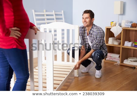 Foto stock: Family Couple Assembling Baby Bed At Home
