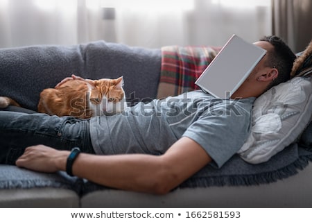 Stock foto: Happy Man With His Pet Cat On Sofa