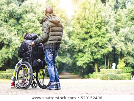 Stockfoto: Disabled Young Man Sitting In A Wheelchair And Looks At The Sea